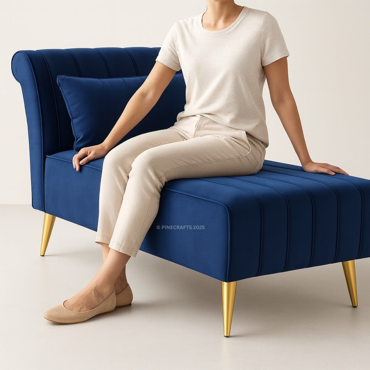 Person sitting on a blue sofa with gold legs against a white background