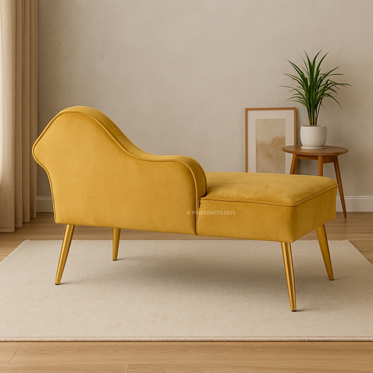 Yellow chaise lounge in a room with a plant and framed picture on a table.