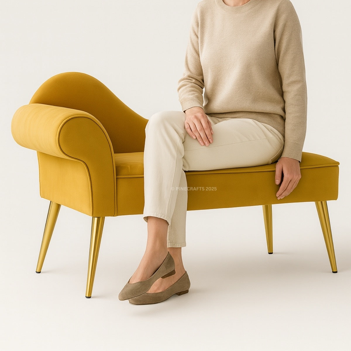 Person sitting on a mustard yellow bench with gold legs against a white background