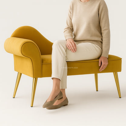 Person sitting on a mustard yellow bench with gold legs against a white background