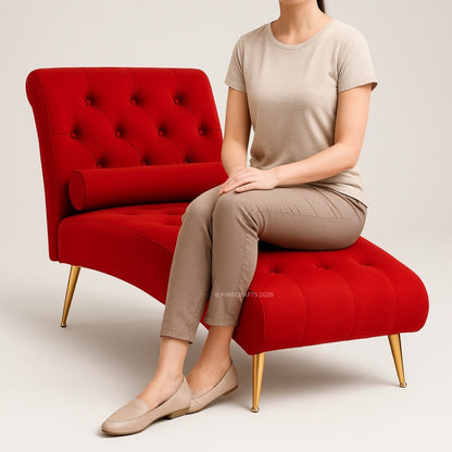 Person sitting on a red tufted chair with gold legs against a plain background