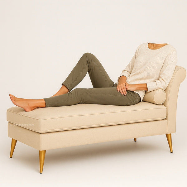 Person sitting on a beige bench with gold legs against a plain background
