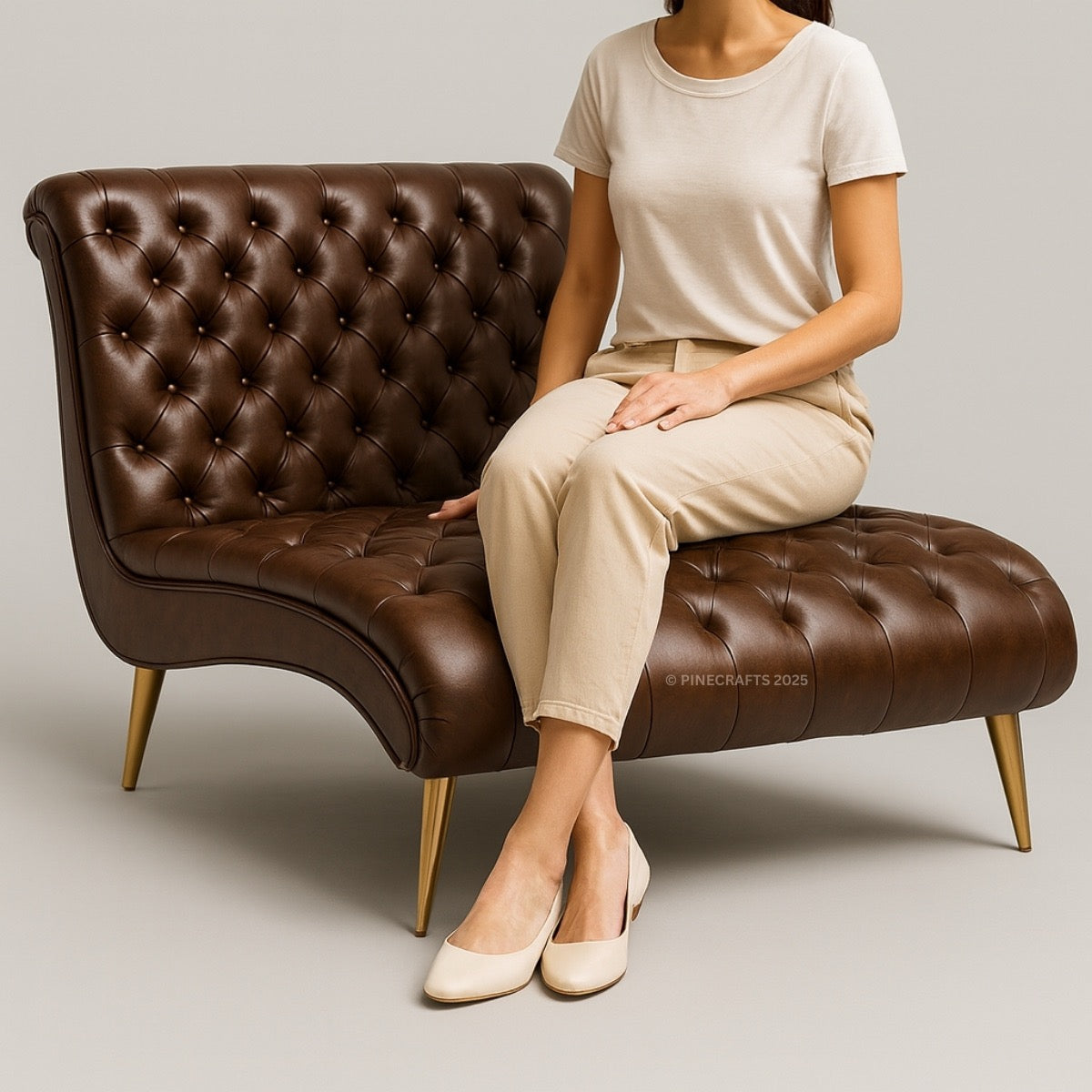 Person sitting on a brown tufted bench with a neutral background