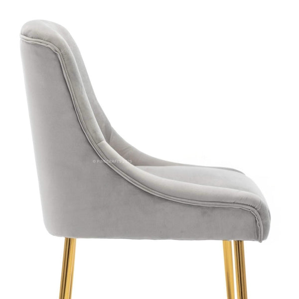 Gray velvet chair with gold legs on a white background