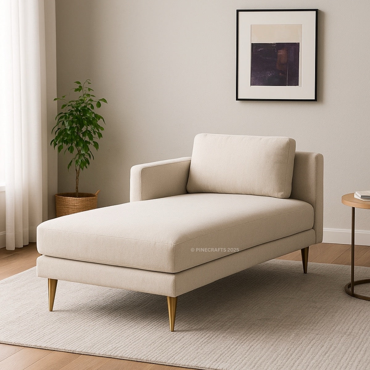 Beige chaise lounge in a living room setting with a plant and framed picture.