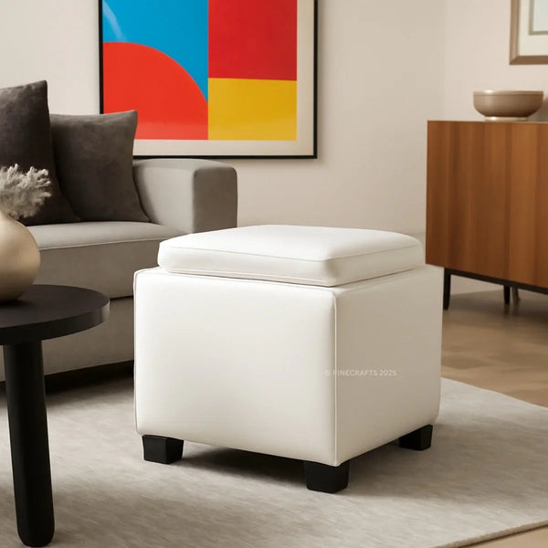 White storage ottoman in a living room setting with a colorful abstract painting on the wall.