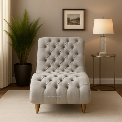 Gray tufted chair in a living room setting with a lamp and plant.