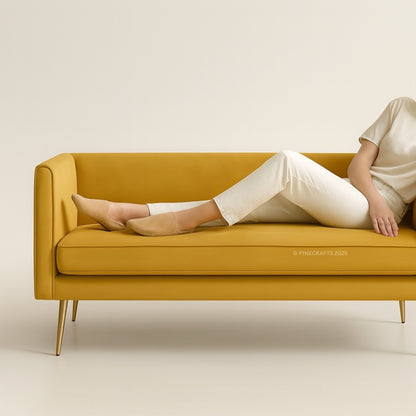 Person sitting on a mustard yellow sofa against a beige background