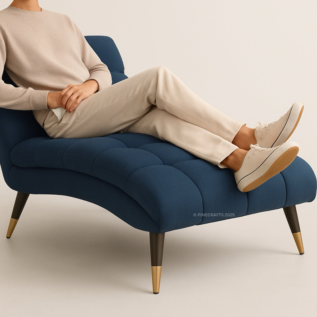 Person sitting on a blue cushioned chair with gold legs against a plain background