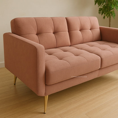 Pink sofa with gold legs on a wooden floor