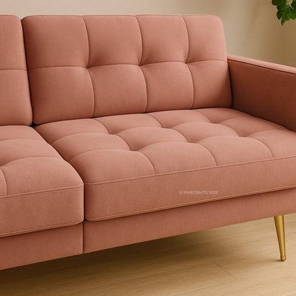 Pink sofa with tufted cushions on a wooden floor.