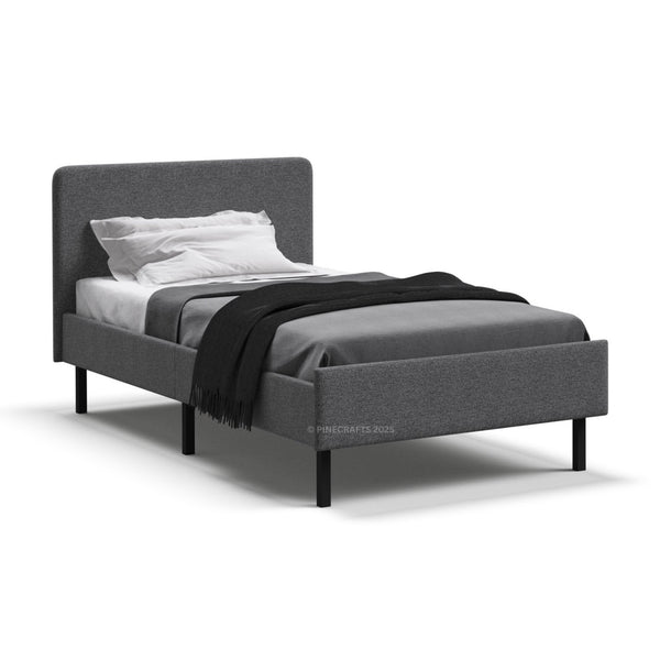 Gray upholstered bed with white bedding and a black throw blanket on a white background