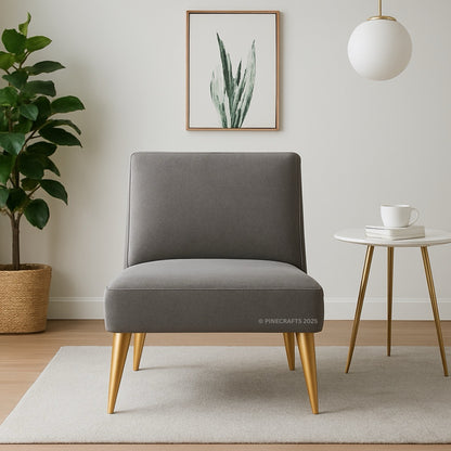 Gray chair with gold legs in a room with a plant, table, and artwork.