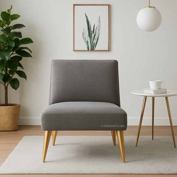 Gray chair with gold legs in a room with a plant, table, and artwork.