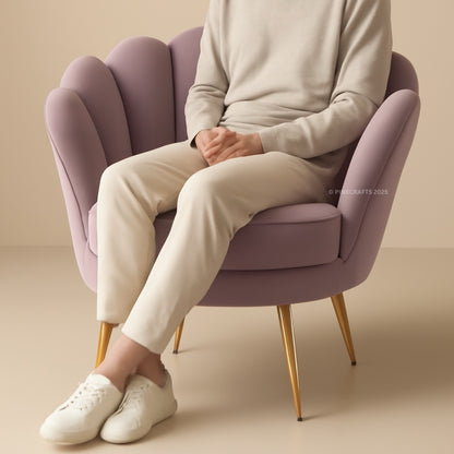 Person sitting on a purple chair wearing a light gray sweater, beige pants, and white shoes.