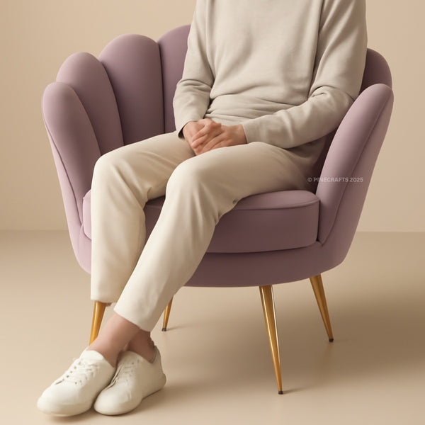 Person sitting on a purple chair wearing a light gray sweater, beige pants, and white shoes.