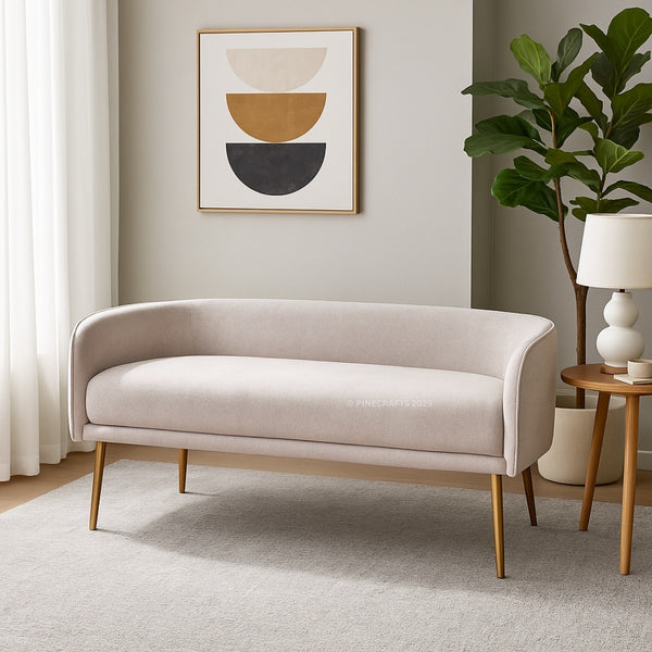 Beige sofa in a living room with a abstract art piece on the wall and a plant.