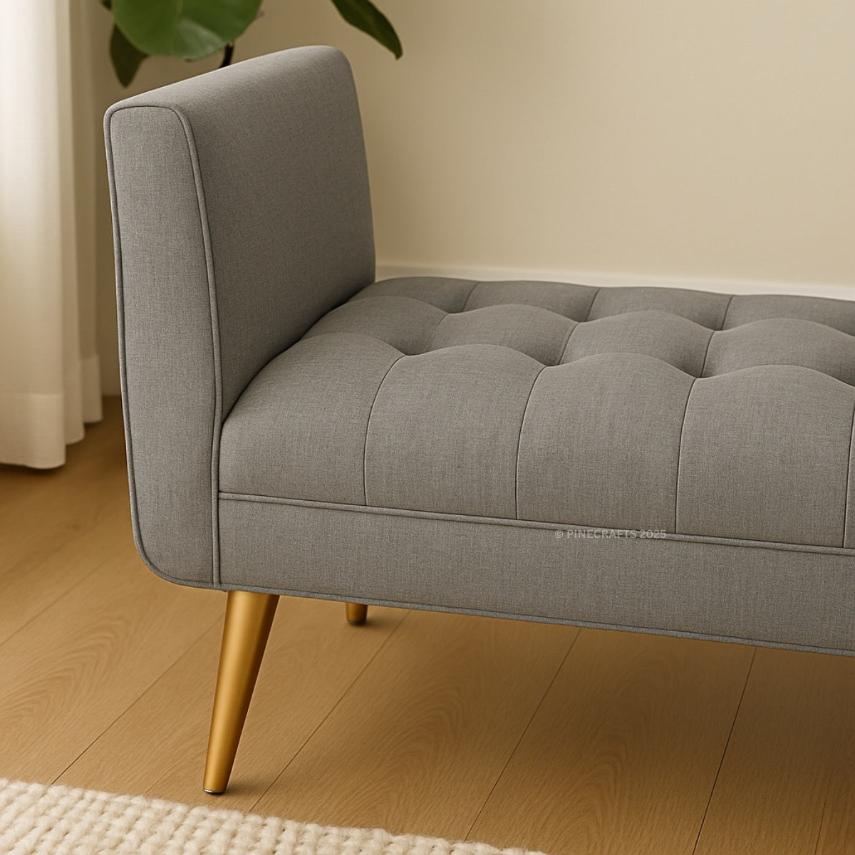 Gray tufted sofa with gold legs on a wooden floor