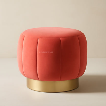 Red cushioned stool with gold base on a beige background