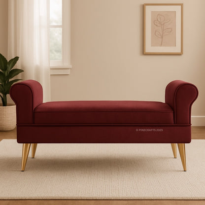 Red bench with gold legs in a room with a plant and framed picture on the wall.