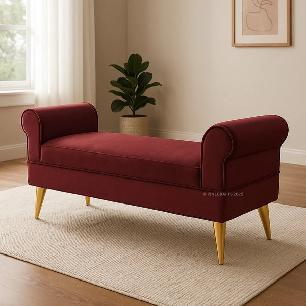 Maroon bench with gold legs in a room with a plant and window