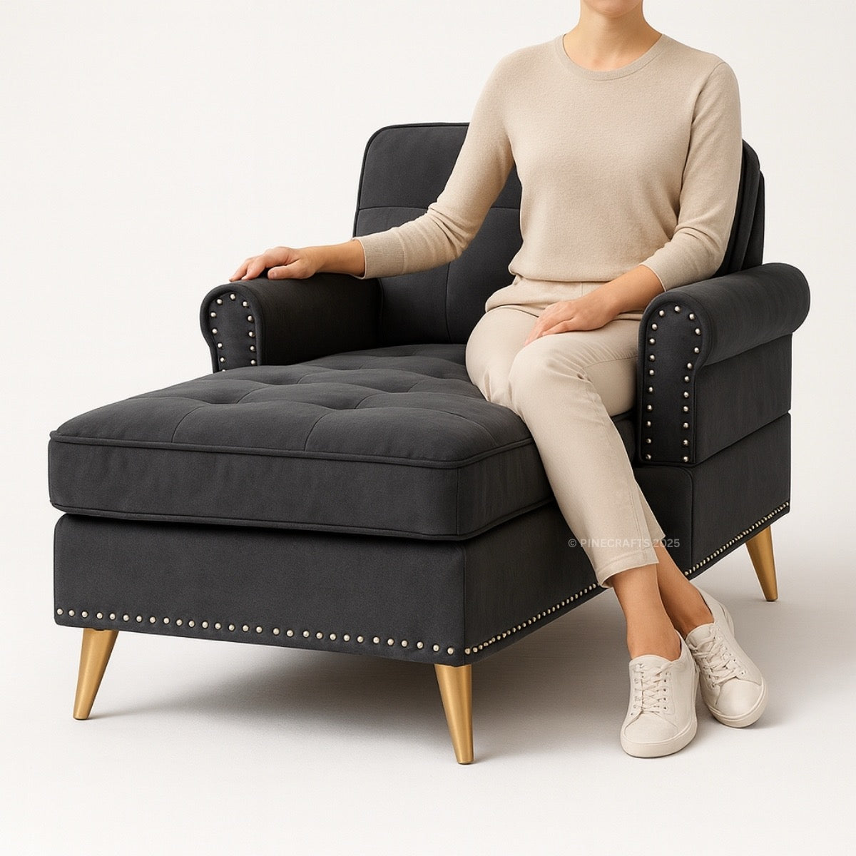 Person sitting on a black armchair with gold legs against a white background