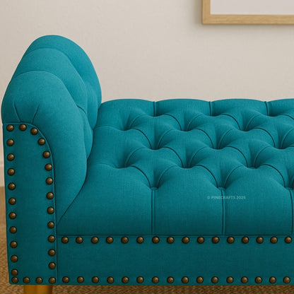Teal tufted sofa with nailhead trim on a neutral background