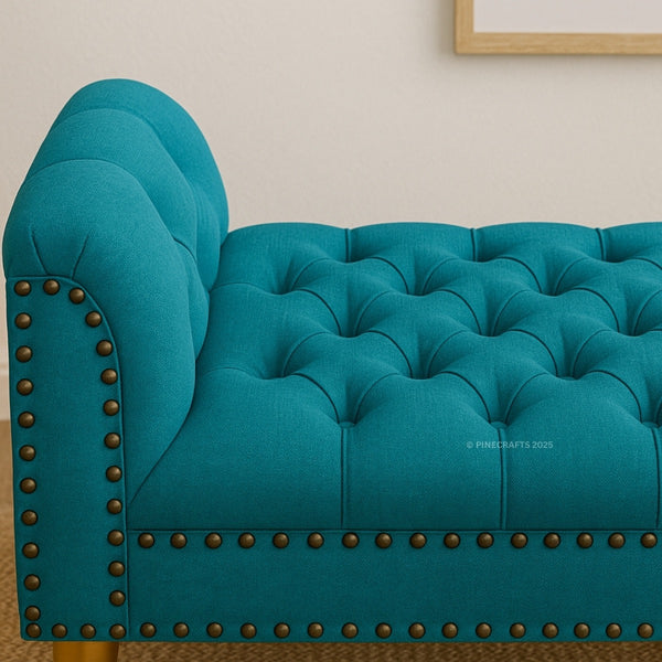 Teal tufted sofa with nailhead trim on a neutral background