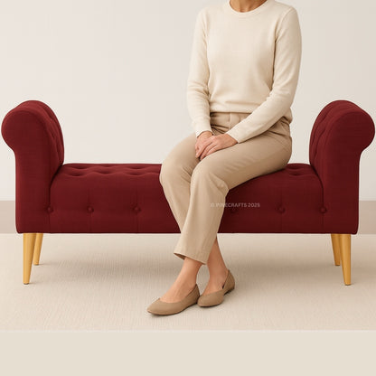 Person sitting on a red bench wearing beige pants and a cream sweater.