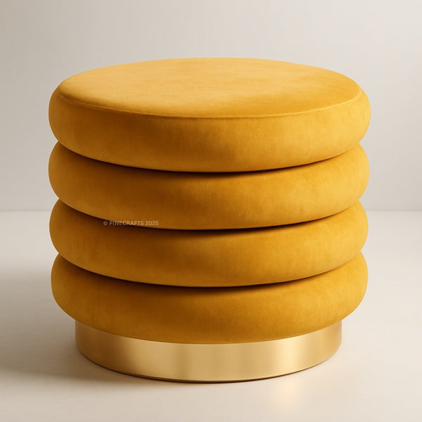 Yellow ottoman with a gold base on a light background