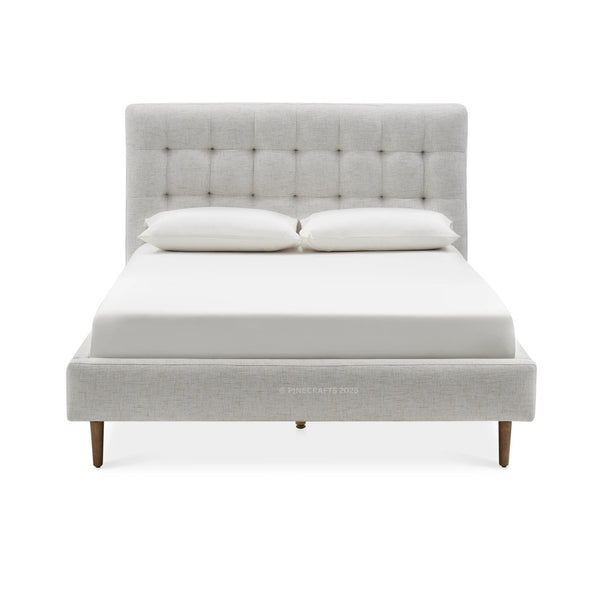 Gray upholstered bed with white bedding on a white background