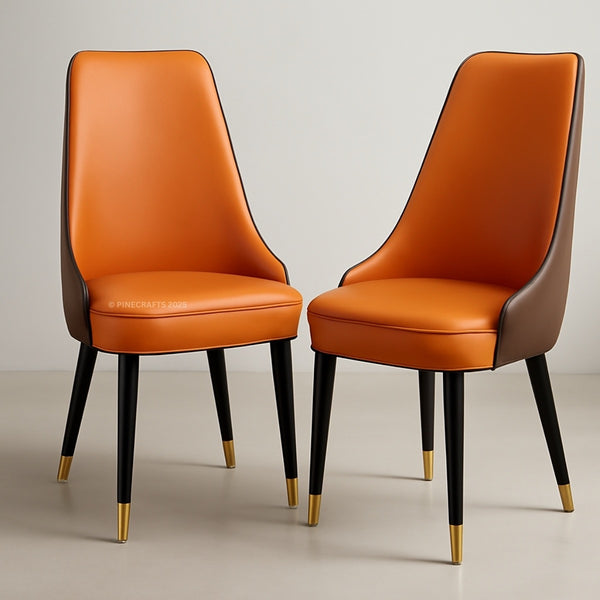 Two orange chairs with black legs and gold tips on a neutral background