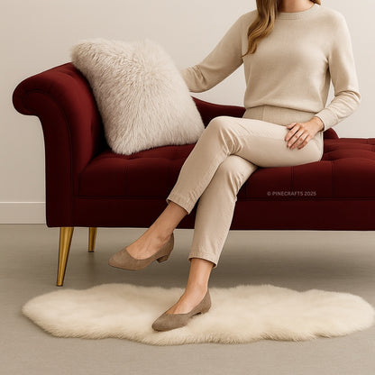 Woman sitting on a red sofa with a white fur throw and rug in front