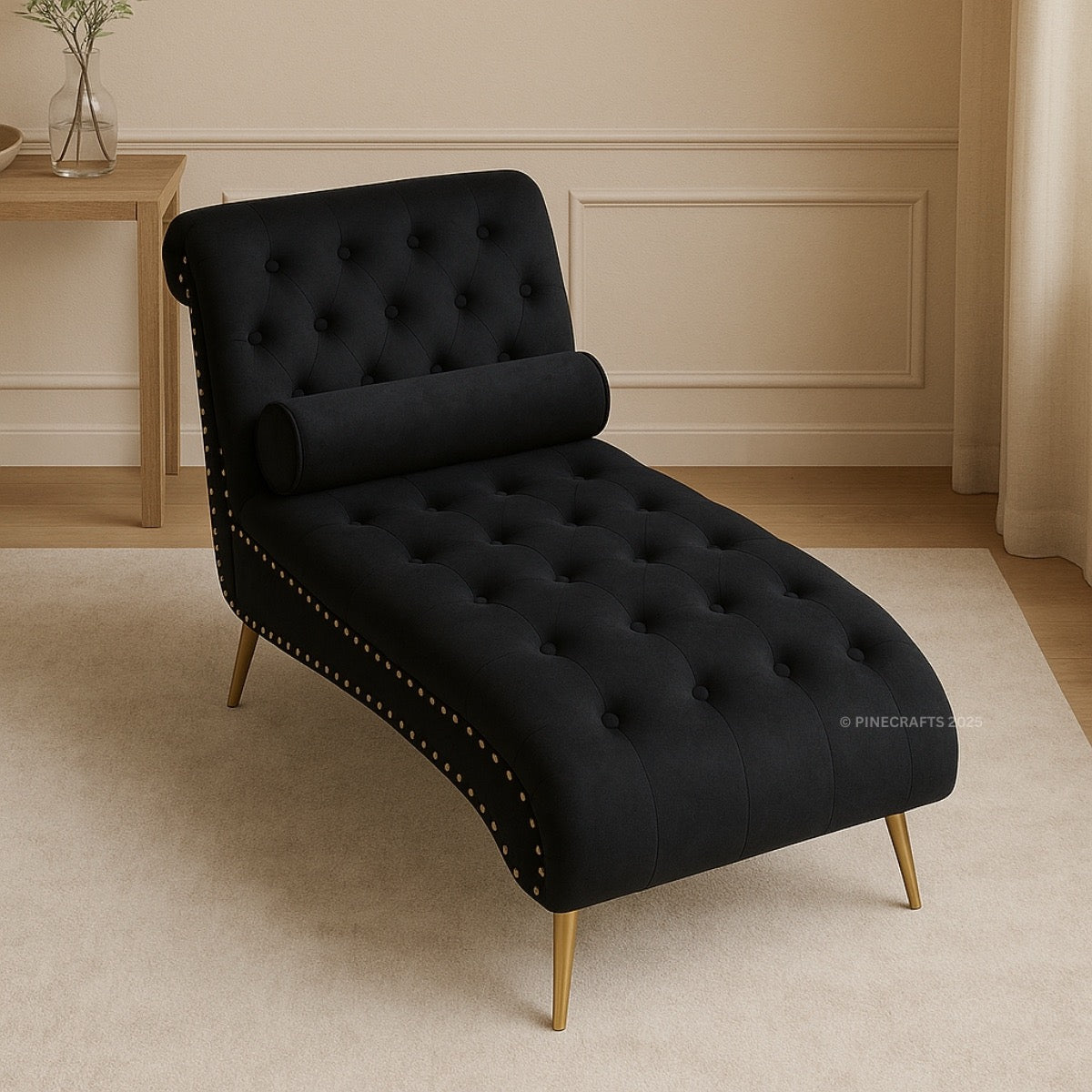 Black tufted chaise lounge with gold legs in a room setting