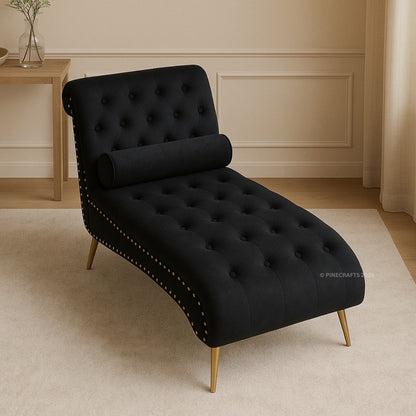 Black tufted chaise lounge with gold legs in a room setting