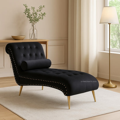 Black chaise lounge in a living room setting with a lamp and table in the background.