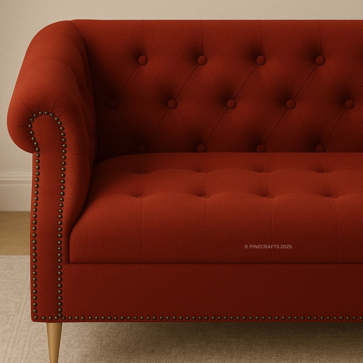 Red tufted sofa with nailhead trim in a neutral setting