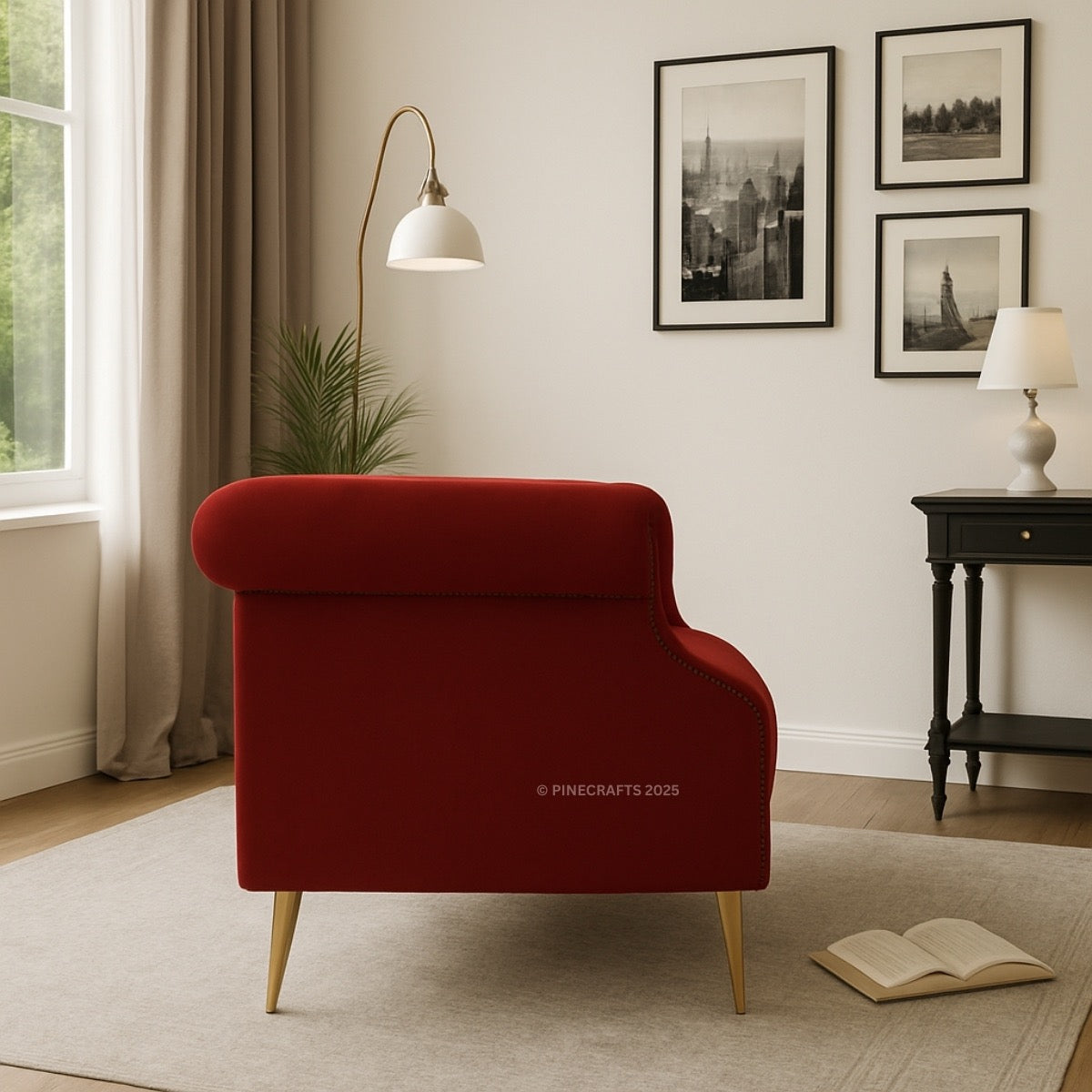 Red armchair in a living room with framed pictures on the wall and a lamp.