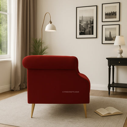 Red armchair in a living room with framed pictures on the wall and a lamp.