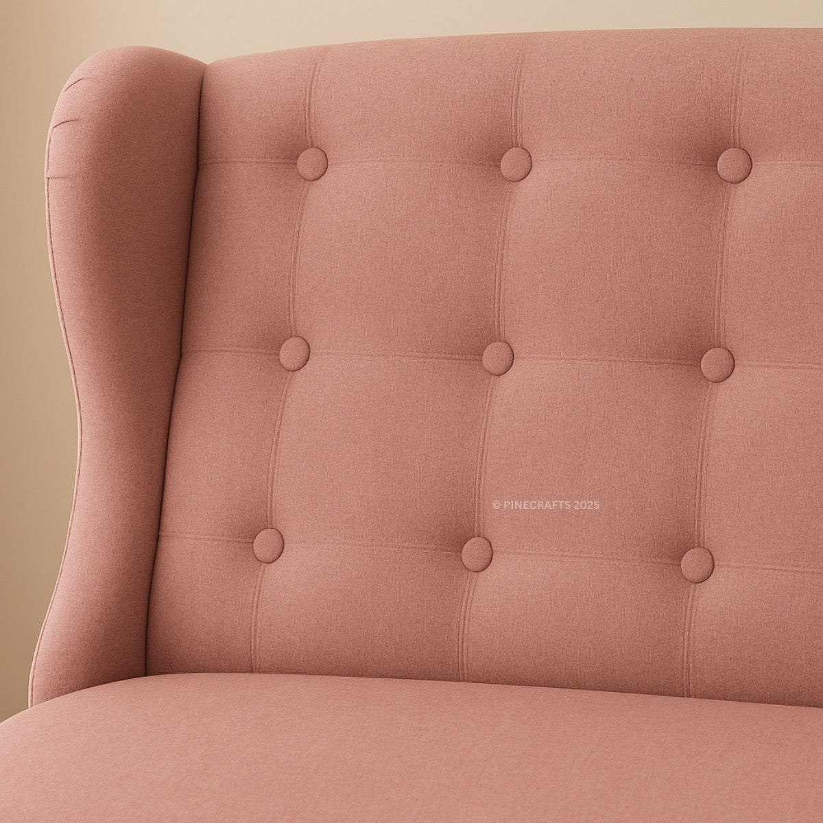 Close-up of a pink upholstered chair with buttoned backrest on a beige background