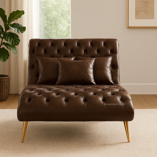 Brown leather sofa with tufted backrest and gold legs in a room with a plant and framed picture.