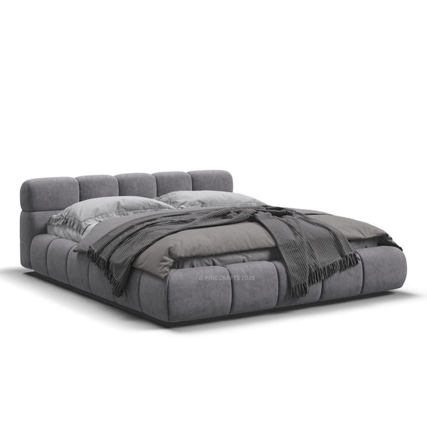 Gray upholstered bed with pillows and a blanket on a white background