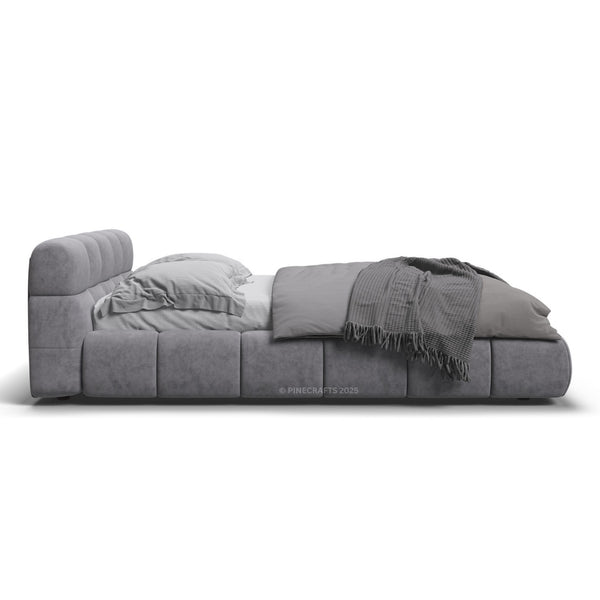 Gray upholstered bed with bedding on a white background