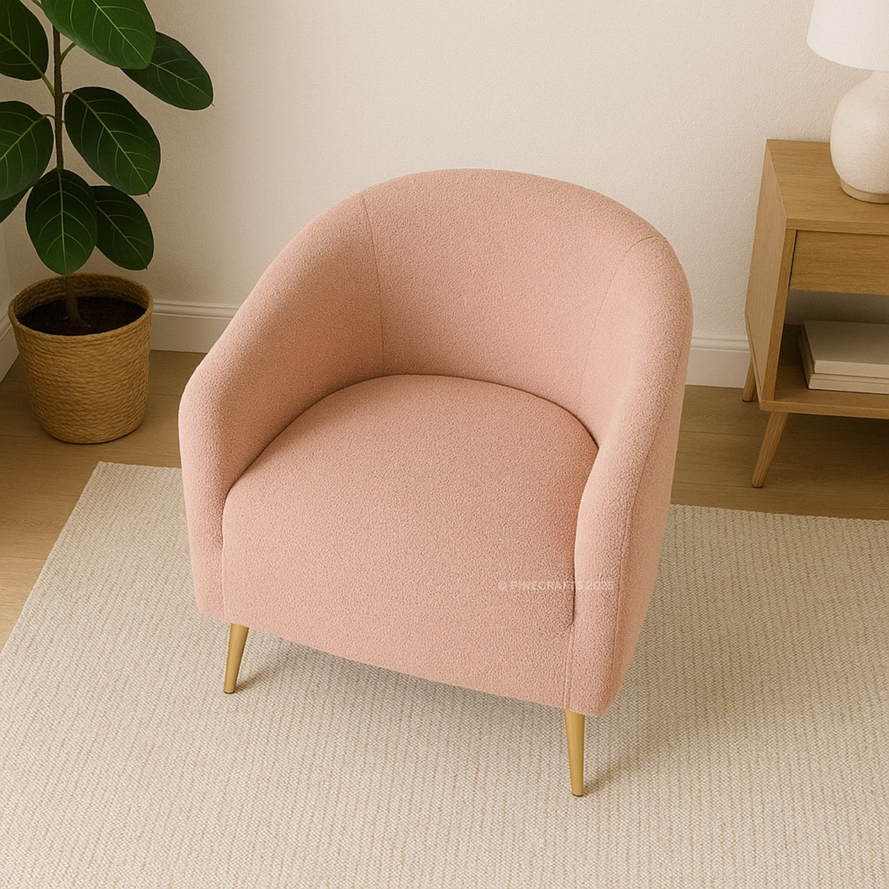 Pink armchair in a room with a plant and wooden side table.