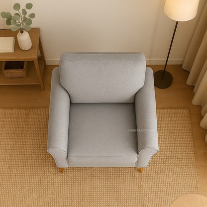 Gray armchair in a room with wooden floor and side table.