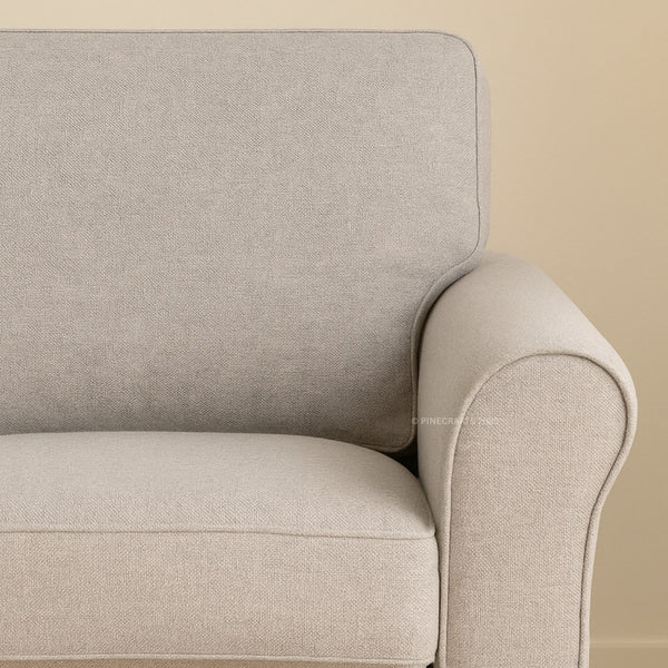 Close-up of a beige armchair against a beige wall
