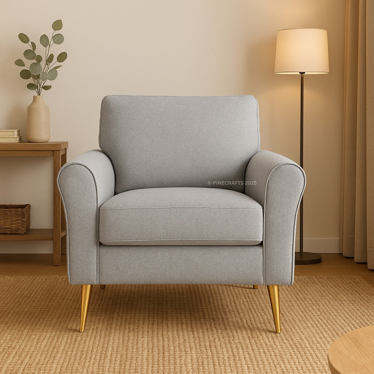 Gray armchair in a living room setting with a lamp and plant.