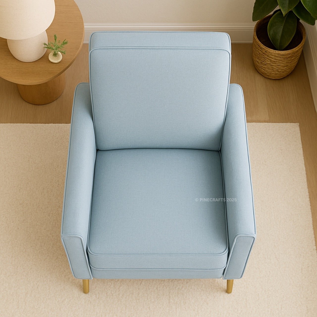 Light blue armchair in a room with a wooden side table and plant.