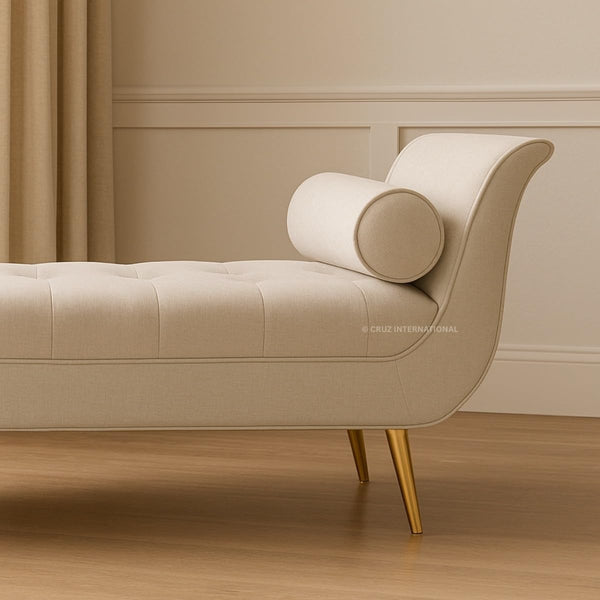 Beige sofa with gold legs in a room with beige walls and wooden floor.