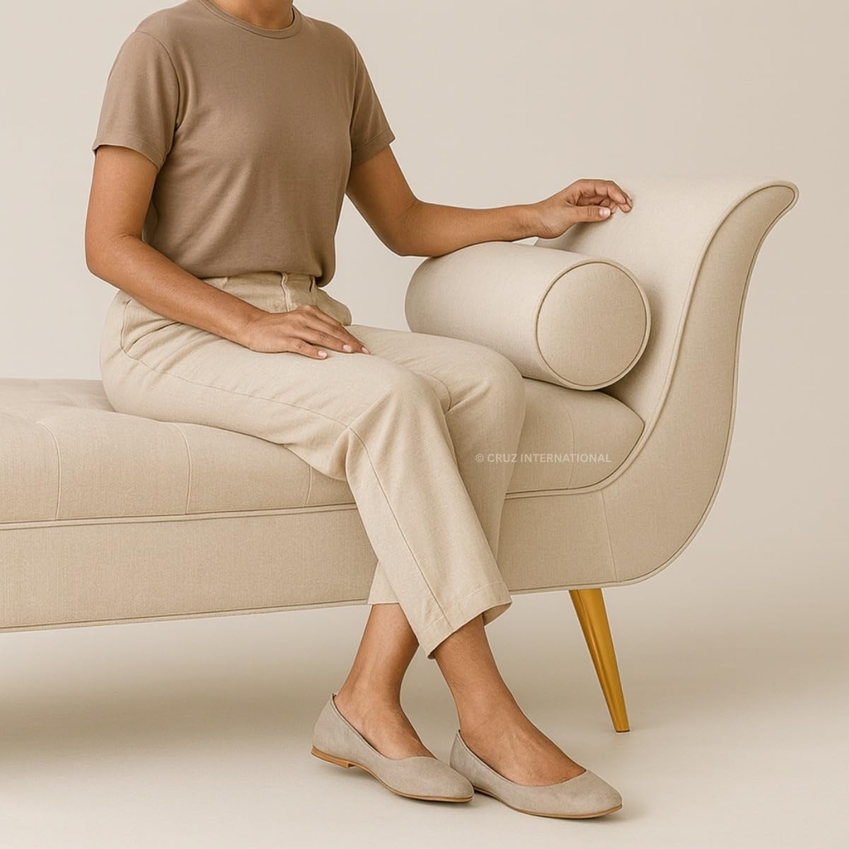 Person sitting on a beige armchair wearing a beige outfit.